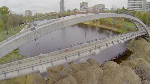 Dívka chodí mostu přes Cherkizovsky rybník — Stock video