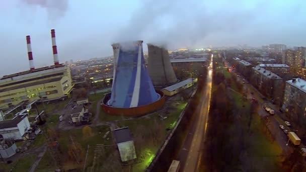 Street traffic near power plant with tubes which throw out smoke — Stock Video