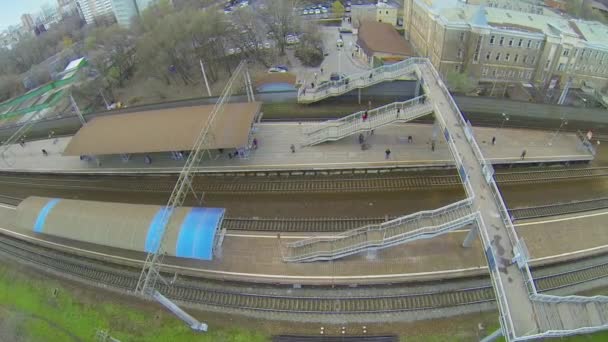 Menschen laufen am Herbsttag über Fußgängerbrücke am Bahnhof — Stockvideo