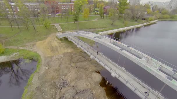 Mensen wandeling door brug over Cherkizovsky vijver — Stockvideo