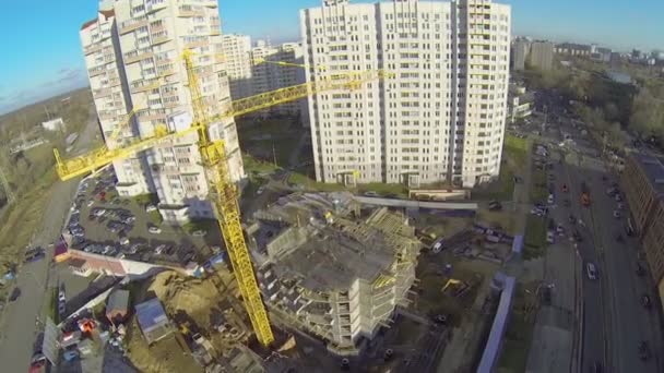 Tall lifting crane works on building site — Stock Video