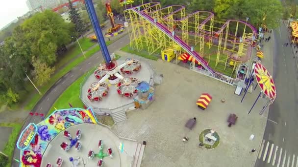 Luces brillantes en el parque de atracciones en día nublado en VVC — Vídeos de Stock