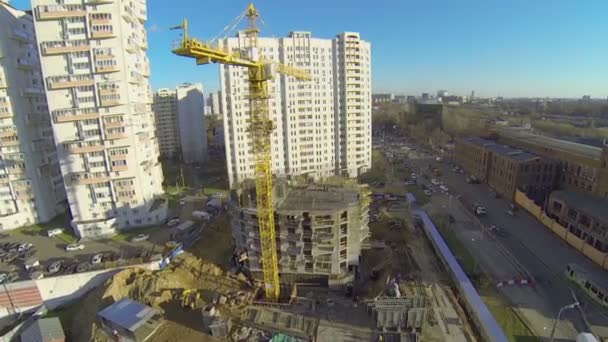 Tall lifting crane works on building site — Stock Video