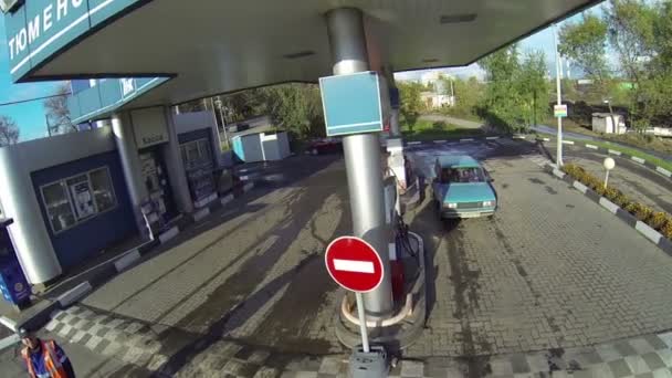 Mavi araba benzin istasyonunda yakıt ikmali için durdu — Stok video