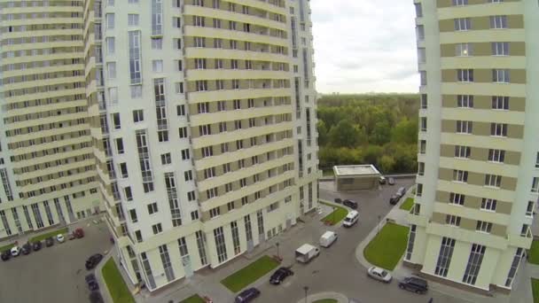 Mensen en auto verplaatsen in parkeerplaats van gebouwencomplex — Stockvideo