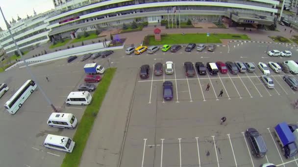 Mensen lopen door de auto parkeren — Stockvideo