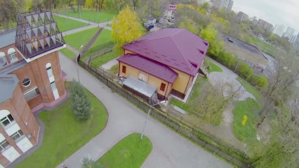 Casa de madera con techo magenta y patio pavimentado redondo — Vídeo de stock