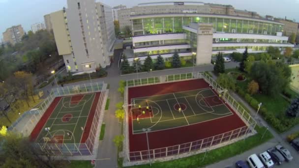 Os alunos jogam basquete e futebol no playground — Vídeo de Stock