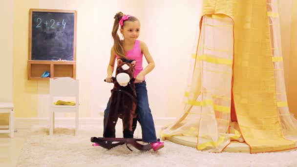 Little girl swinging on rocking horse — Stock Video