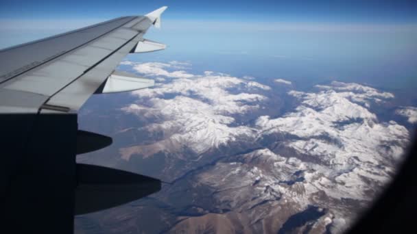 Ala di aereo di linea che vola sopra il paesaggio con montagne — Video Stock