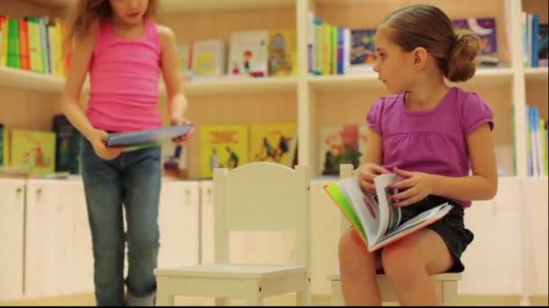 Little girl reading book in store — Stock Video