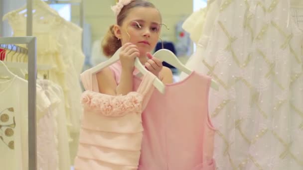 Menina escolhe entre dois vestidos diferentes — Vídeo de Stock