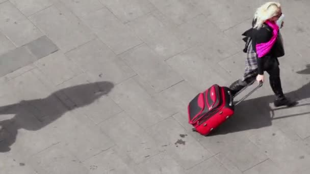 Жінка тягне чемодан на тротуар — стокове відео