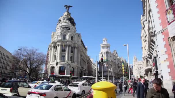 Mensen lopen aan de Gran Via straat met verkeer — Stockvideo