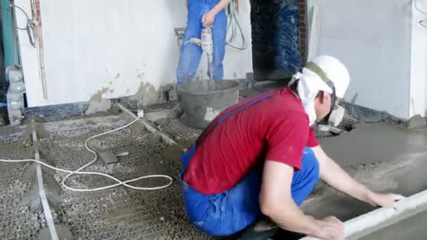 Gruppe von Arbeitern legt Zement auf den Boden — Stockvideo