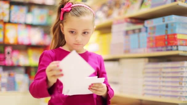 Petite fille regarde à travers les enveloppes — Video