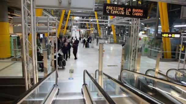 Passagerarna går i hall med rulltrappor på Barajas flygplats — Stockvideo