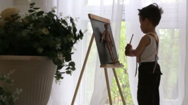 küçük çocuk şövale üzerinde boyalar