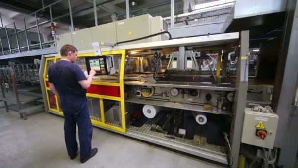 Homem configurar o trabalho da máquina de embalagem — Vídeo de Stock