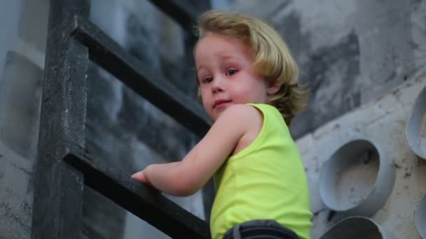 Cute little boy climbs on ladder — Stock Video