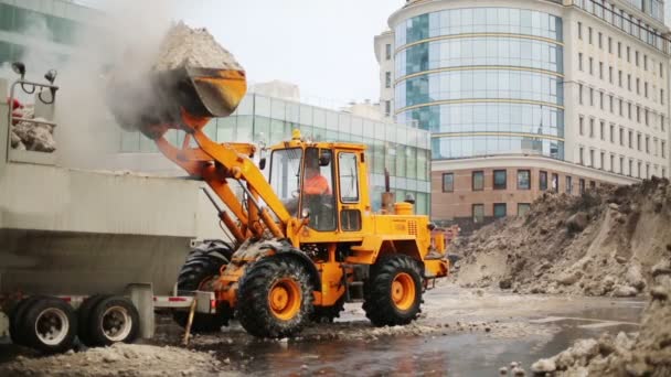 Bulldozer charge la neige mouillée aux camions — Video