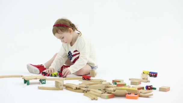 Little girl plays with toy railroad — Stock Video