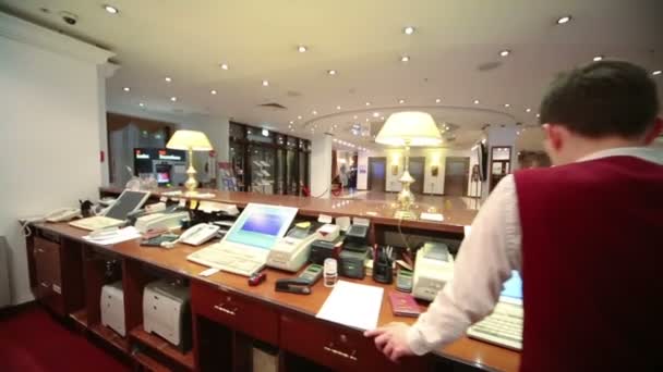 Receptionisten bakom skrivbord reception på hotel — Stockvideo
