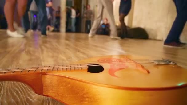 Trä gitarr ligger på golvet — Stockvideo