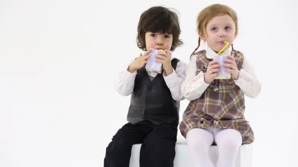 Little boy and girl drink juice — Stock Video