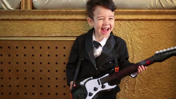 Little boy playing guitar toy — Stock Video