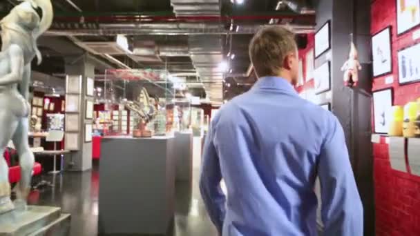 Mann läuft an Statuette im Museum entlang — Stockvideo