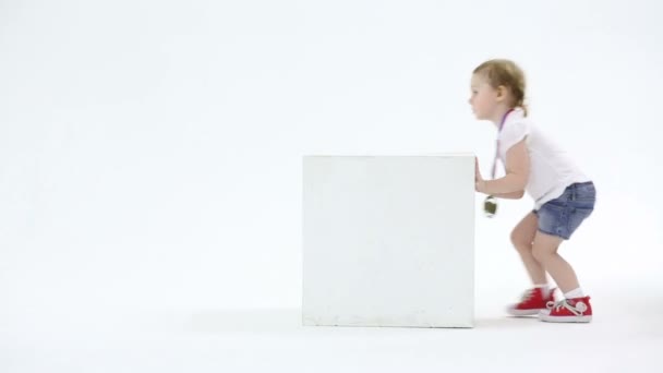 Little cute girl pushes cube — Stock Video