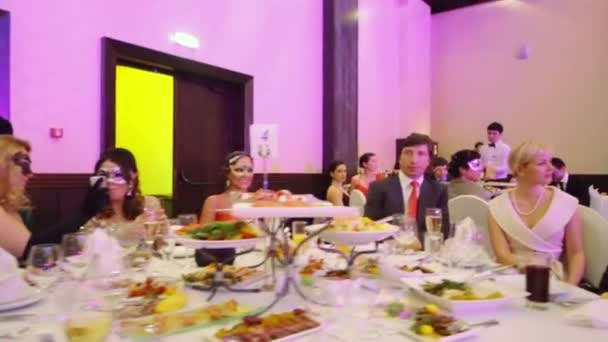 Menschen am Tisch beim Maskenball — Stockvideo