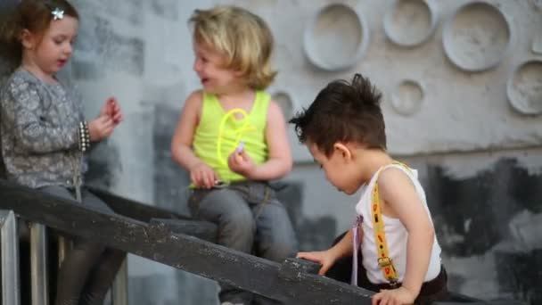 Merdivenlerde oturan üç mutlu çocuk — Stok video
