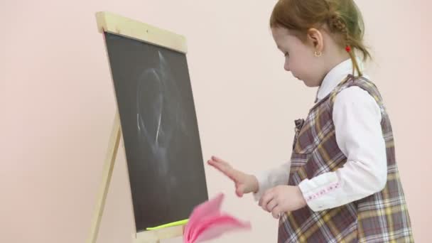 Little girl draws at chalkboard — Stock Video