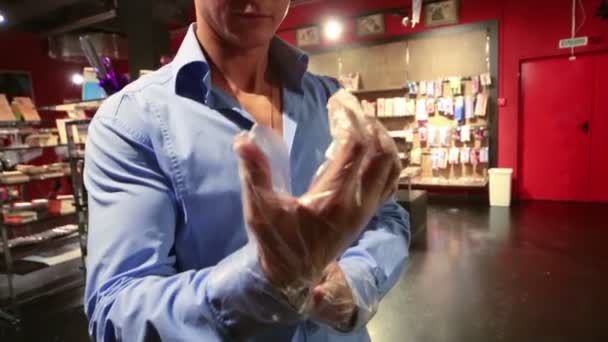 Man probeert transparante handschoenen in winkel — Stockvideo