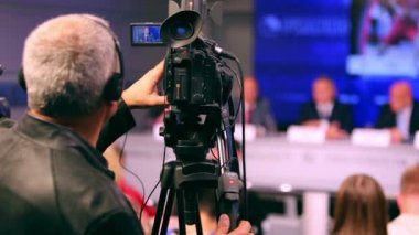 Basın toplantısı üzerinde çalışan kameraman