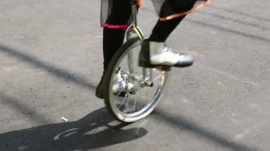 Tek tekerlekli bisiklete binen palyaçonun ayakları