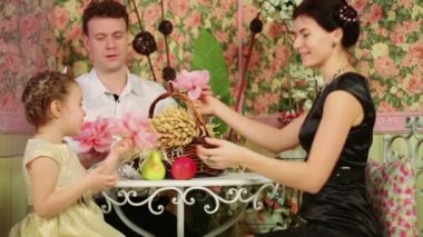 Çiçeklerle masada oturan aile