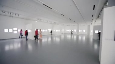 İnsanlar fotoğraf sergisinde yürüyor