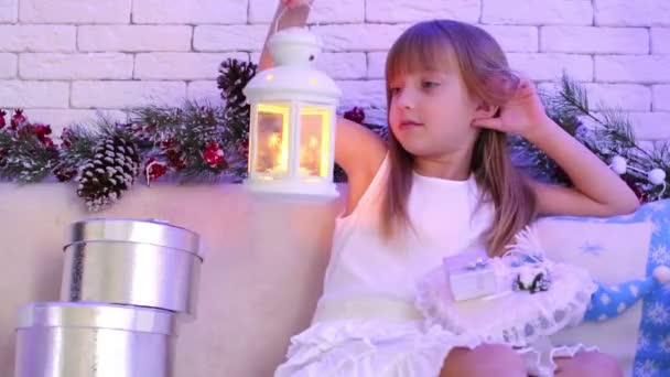 Дівчина сидить на дивані з різдвяні подарунки — стокове відео