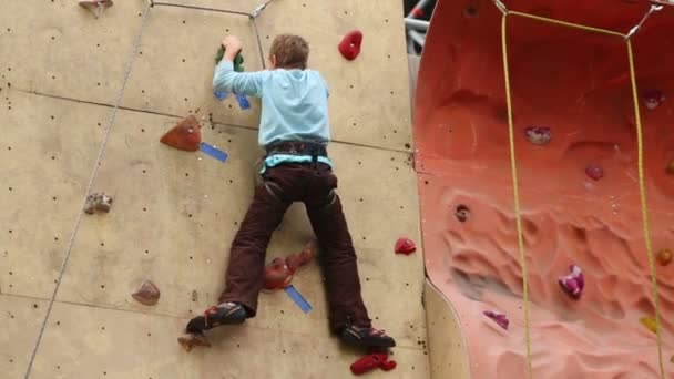 Boy descends down from steep wall — Stock Video