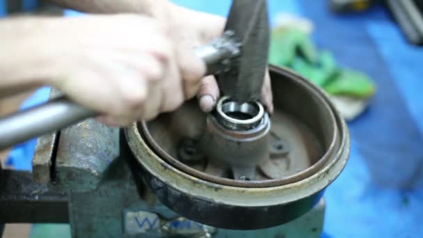 Man mounts bearing hub in wheel — Stock Video