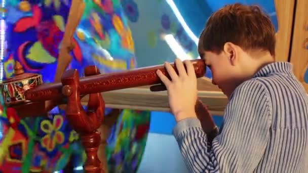 Little boy looking in wooden tube — Stock Video