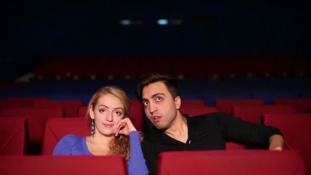 Young man and woman in cinema hall — Stok video