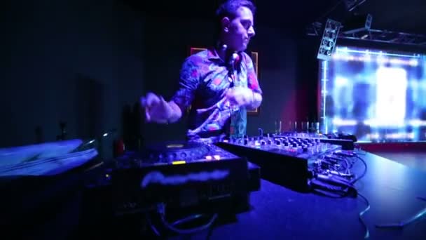 DJ en su lugar de trabajo en discoteca — Vídeos de Stock