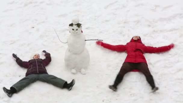 Mutter und Tochter liegen auf Schnee — Stockvideo