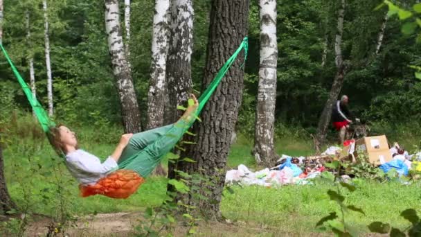 Young girl lies in hammock — Stock video