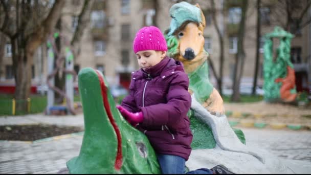 Дівчина грає на ігровому майданчику з скульптурами — стокове відео