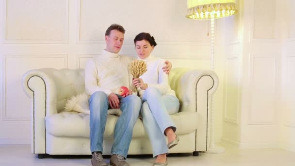 Couple sitting on sofa — Stock Footage Couple sitting on sofa Video Clip